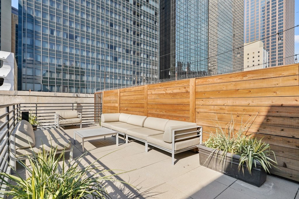 Beautiful rooftop patio space with wooden fence and views of the Dallas buildings at Mid Elm Lofts in Dallas, TX