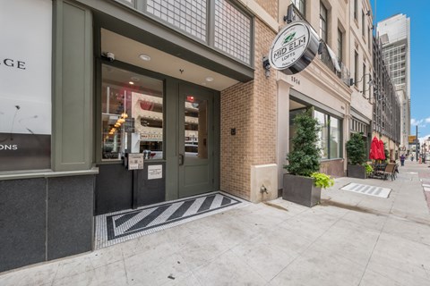 A storefront with a black and white striped mat in front.