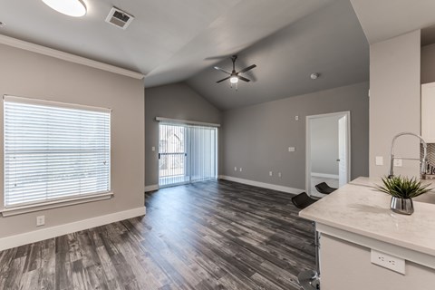 A spacious room with a ceiling fan and sliding glass doors.