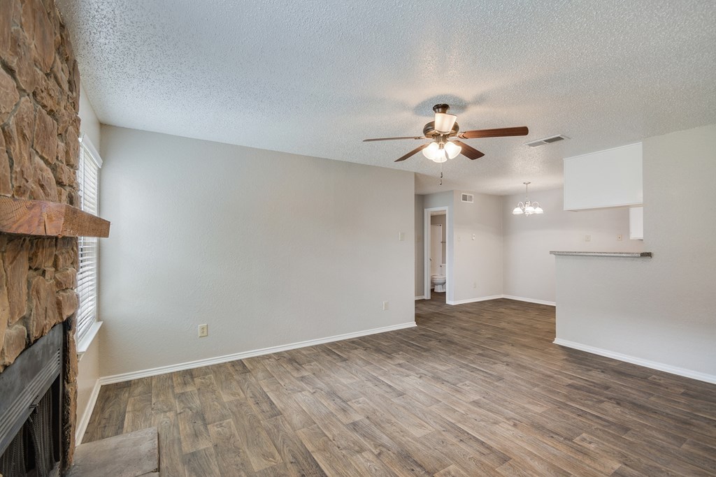 Living Room with Fireplace and Ceiling Fan at Bookstone and Terrace Apartments in Irving, Texas
