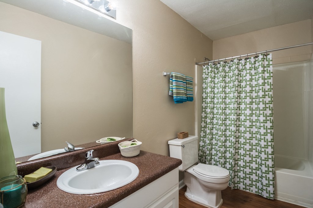 a bathroom with a shower toilet and sink and a mirror at Dunwoody Pointe in Sandy Springs, GA