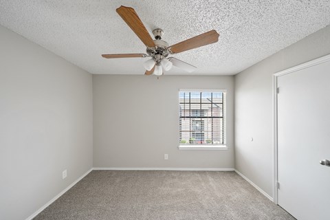 a bedroom with a ceiling fan and a window