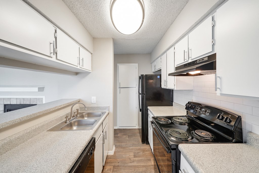 a kitchen with white cabinets and a black stove top oven