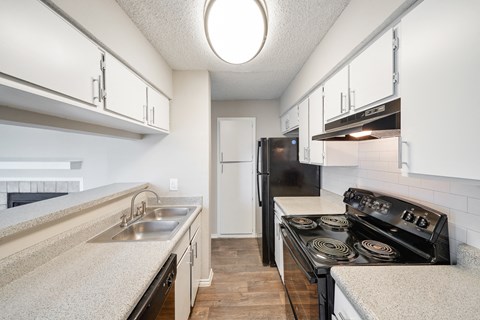 a kitchen with white cabinets and a black stove top oven
