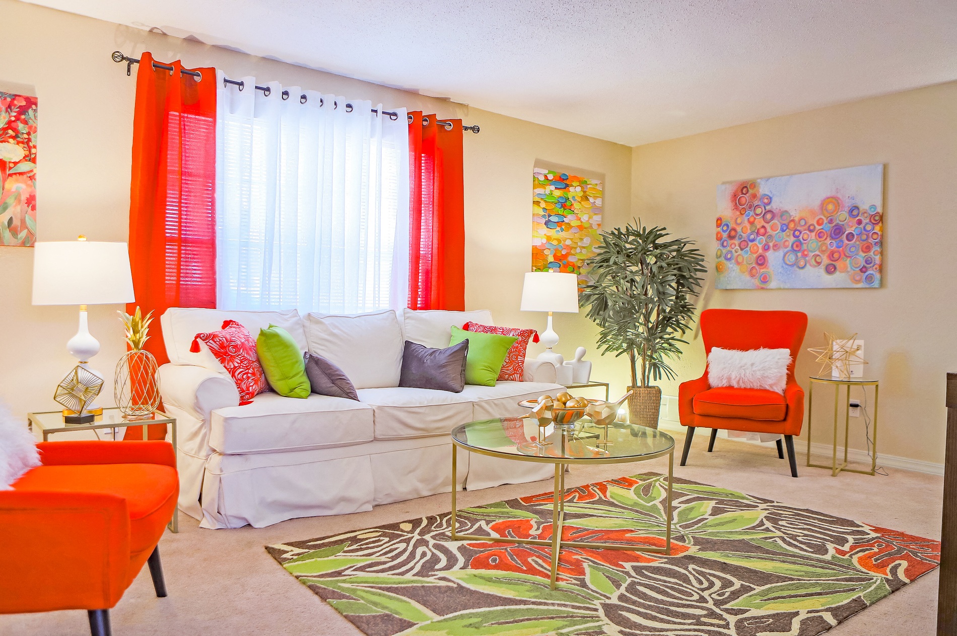 a living room with orange chairs and a white couch