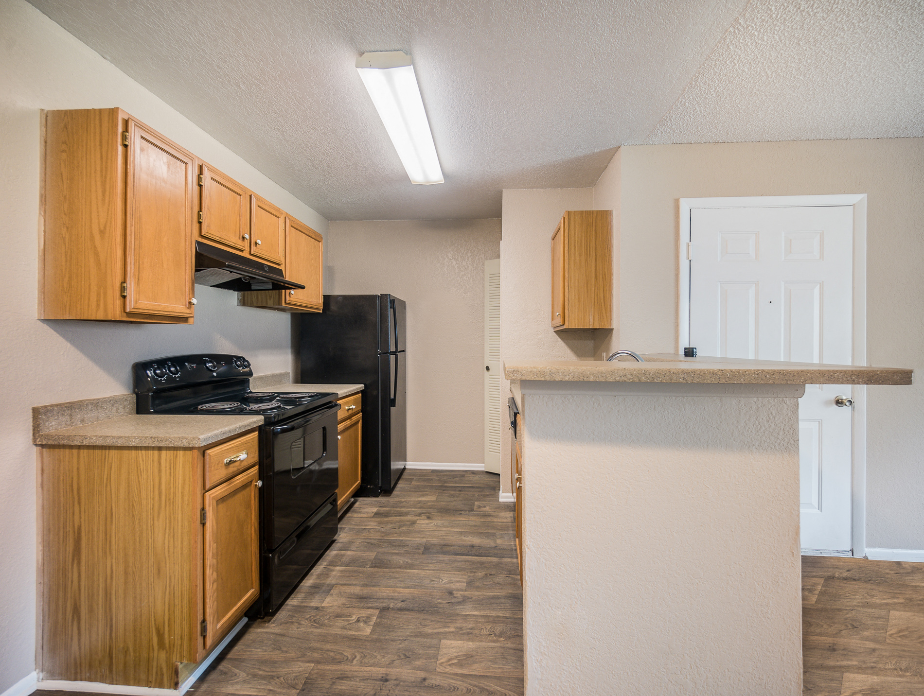 a kitchen with wood cabinets and a black stove and refrigerator