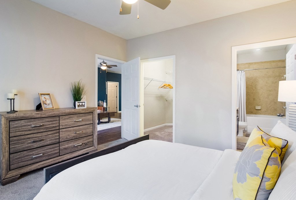 a bedroom with a bed and a dresser in a room