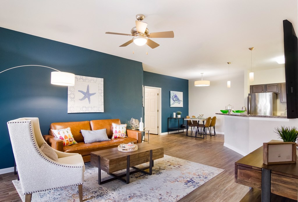 a living room with blue walls and a ceiling fan