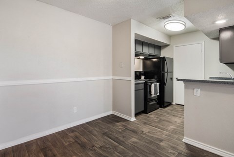 an empty apartment with a kitchen and a refrigerator and a sink