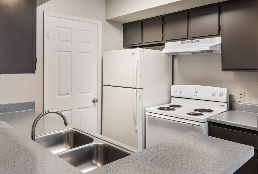 a kitchen with white appliances and a sink and a refrigerator