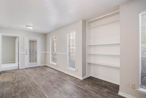an empty room with white shelves and a door