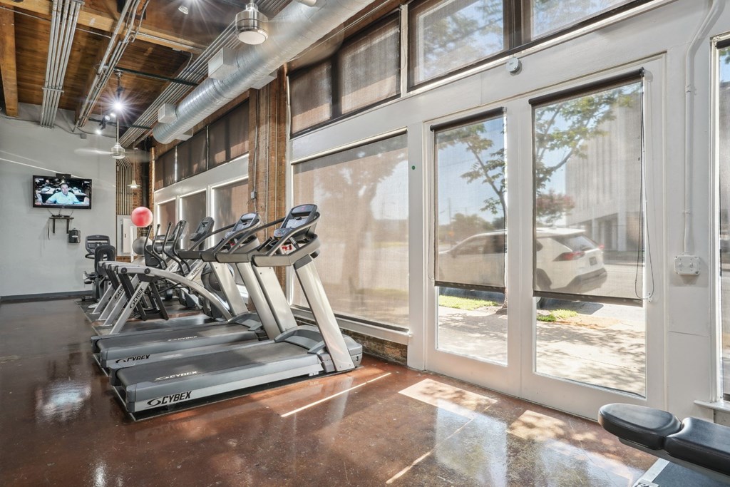 Murray Building gym equipped with cardio equipment and large windows | Deep Ellum Lofts in Dallas, TX