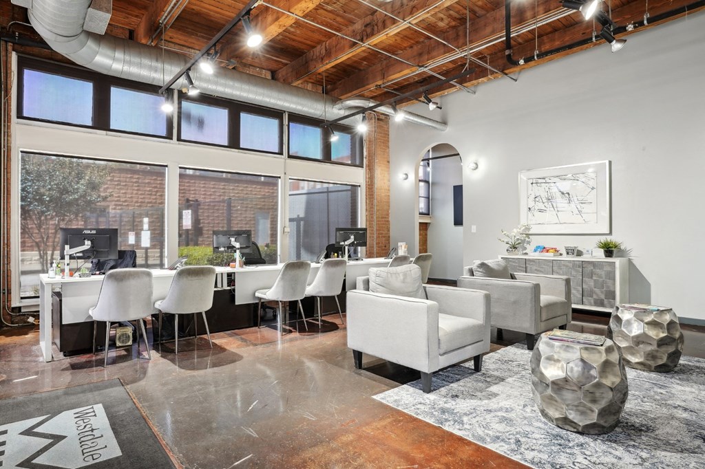 Deep Ellum Lofts Leasing Office with three desks and single seater couches | Deep Ellum Lofts in Dallas, TX