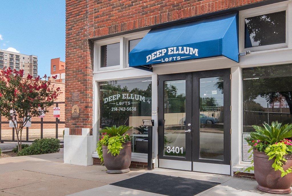a blue awning over a door with glass windows and a window sign that reads deep
