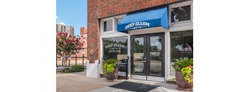 a blue awning over a door with glass windows and a window sign that reads deep