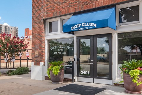 a blue awning over a door with glass windows and a window sign that reads deep
