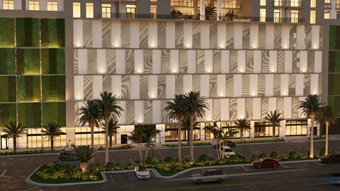 A modern building with a white facade and palm trees in front.