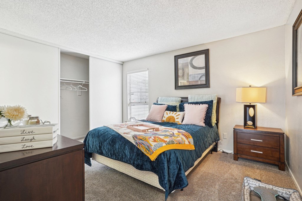 Model A2 floor plan bedroom with a bed, dresser, window Noel on The Parkway in Dallas, TX