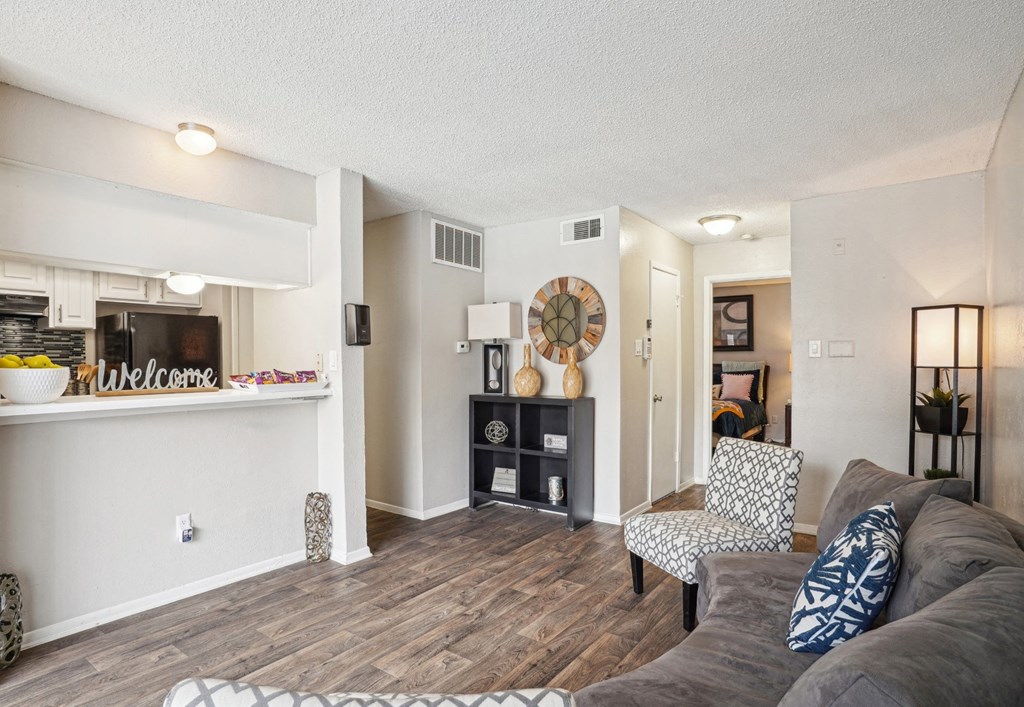 Model A2 floor plan living room with a couch a chair and view of the kitchen Noel on The Parkway in Dallas, TX