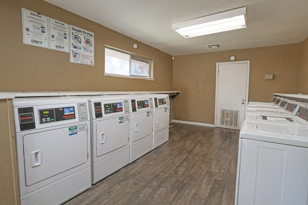 A laundry facility with rows of washers and dryers at Orleans Square in Shreveport, LA