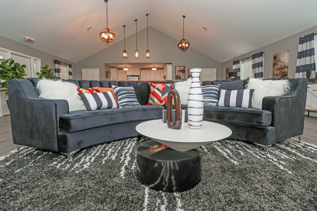 A modern clubhouse with a grey sofa and a round coffee table at Orleans Square in Shreveport, LA