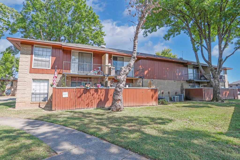 A private patio with a US flag and a balcony storing a bicycle at Orleans Square in Shreveport, LA