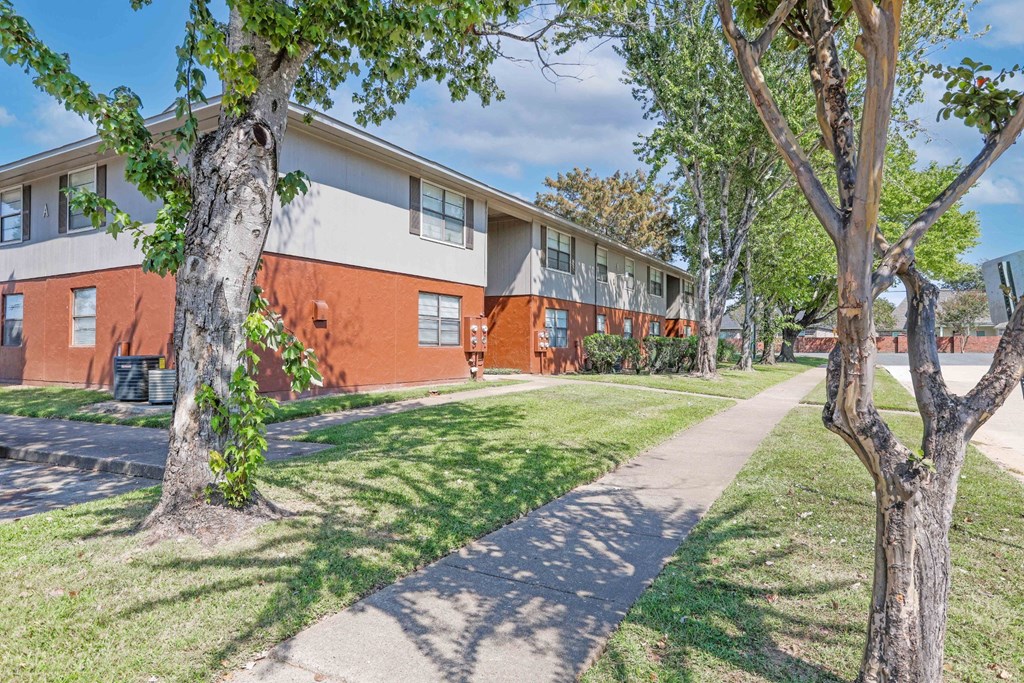 Well-kept landscaping in front of apartment buildings at Orleans Square in Shreveport, LA