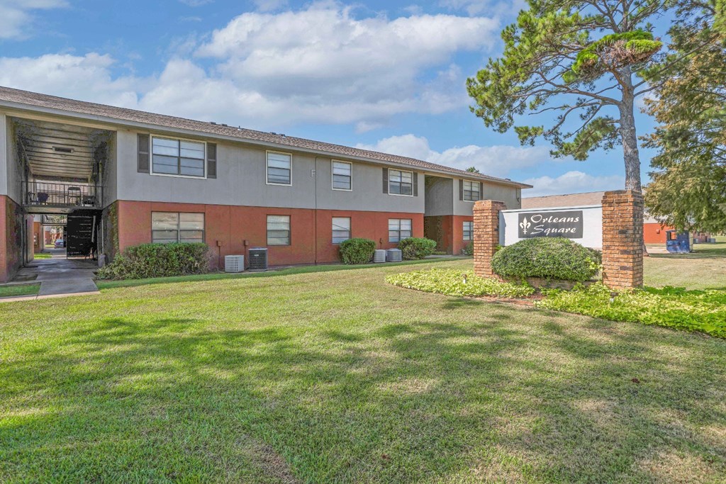 Apartment building with a sign that says "Orleans Square" in front of it at Orleans Square in Shreveport, LA