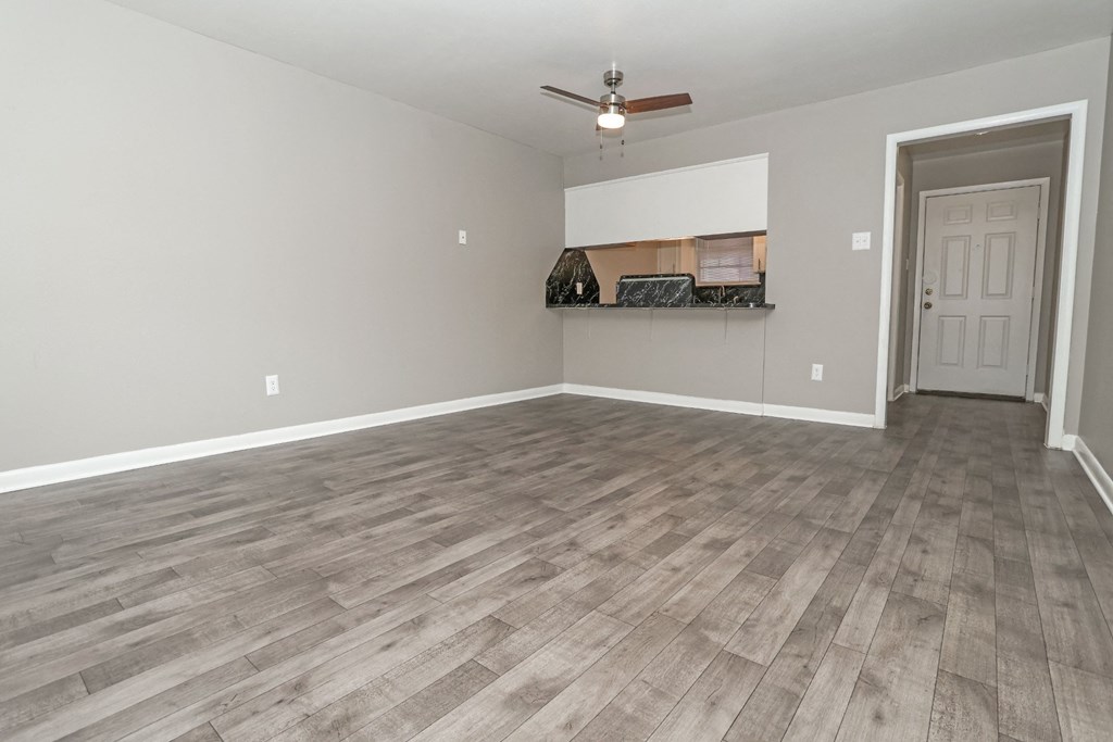 A living room with a ceiling fan and foyer at Orleans Square in Shreveport, LA