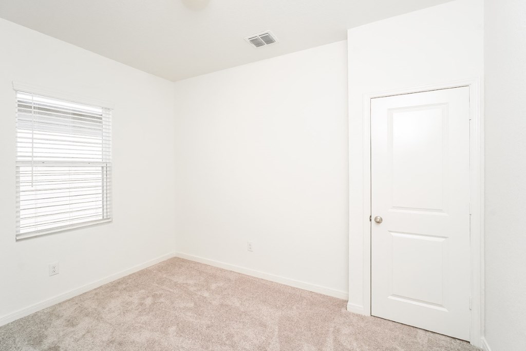 a bedroom with white walls and carpet at Beacon at Meridian, San Antonio