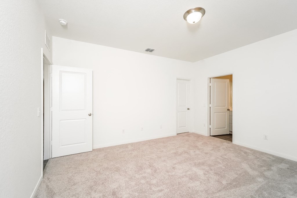 a bedroom with white walls and carpet at Beacon at Meridian, San Antonio