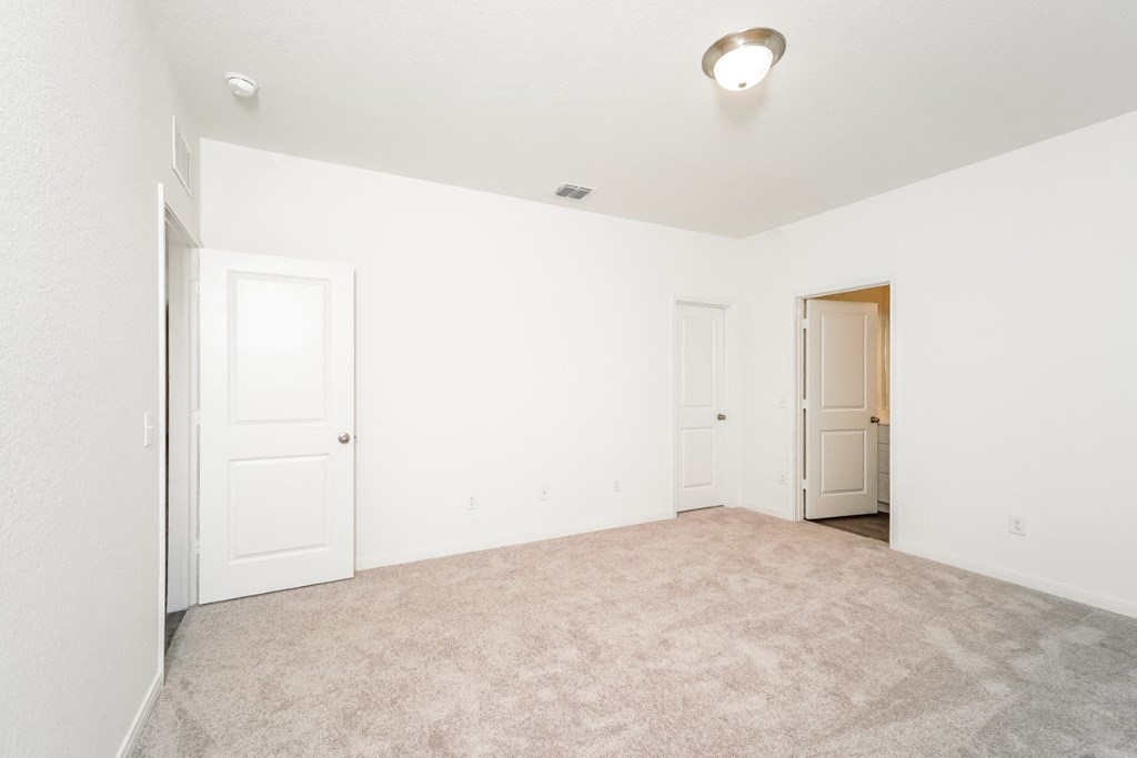 an empty living room with white walls and white doors and carpet