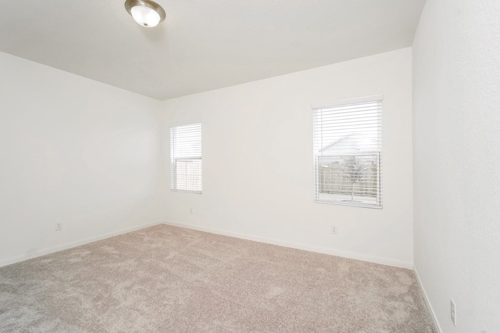Oak master bedroom with plush carpet and two windows at Beacon at Ashley River Landing in Summerville, SC
