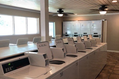 a classroom with a long counter with microwaves and chairs