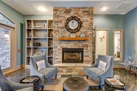 a living room with a brick fireplace and two chairs