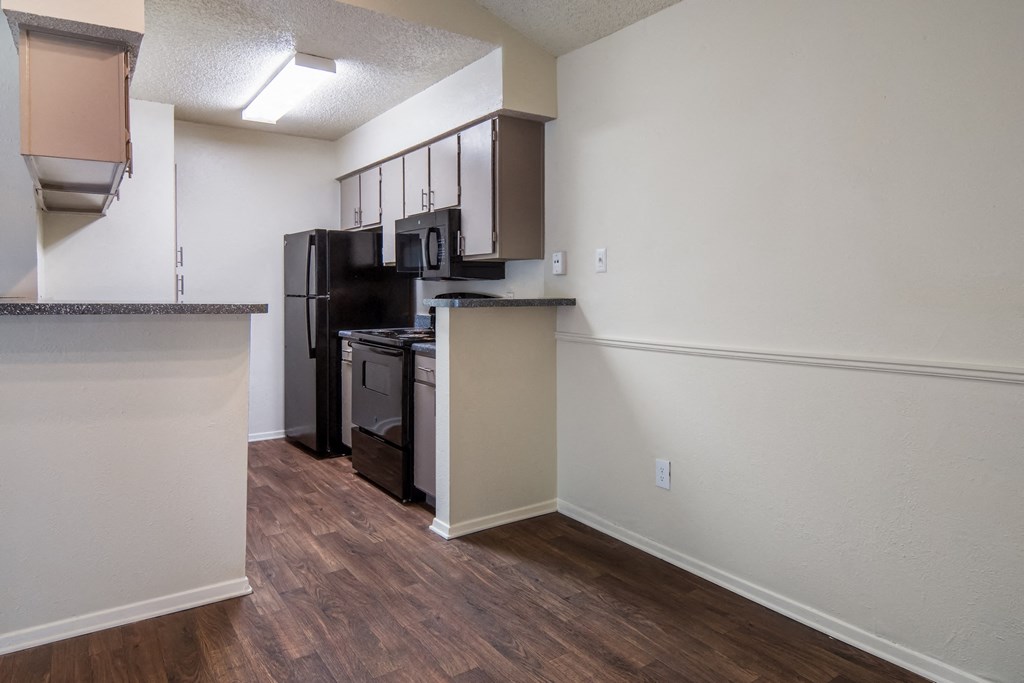 an empty kitchen with a stove and refrigerator and a microwave