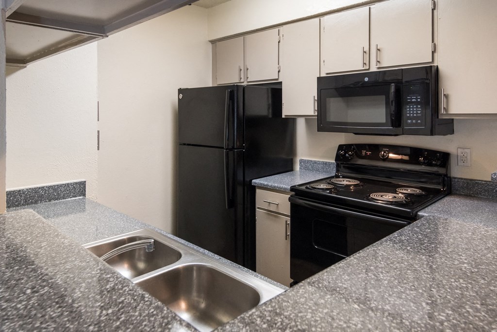 a kitchen with granite counter tops and black appliances
