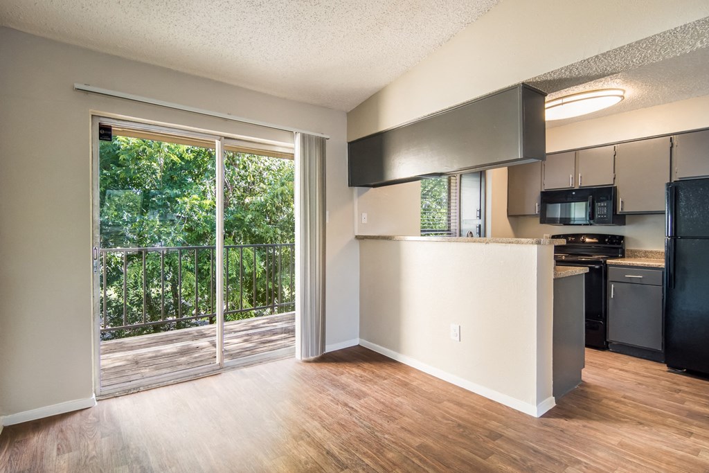 an empty living room and kitchen with a sliding glass door
