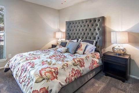 the master bedroom has a large bed with a floral comforter
