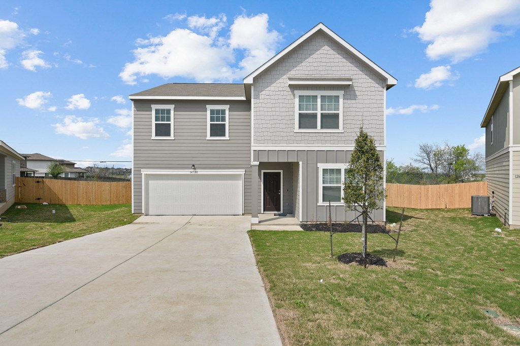 a house with a gray siding and a white garage door at Beacon at Presidential Heights, Texas