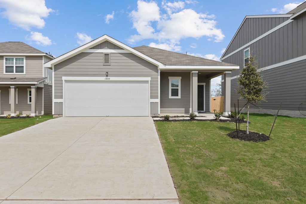 a gray house with a white garage door at Beacon at Presidential Heights, Manor, 78653