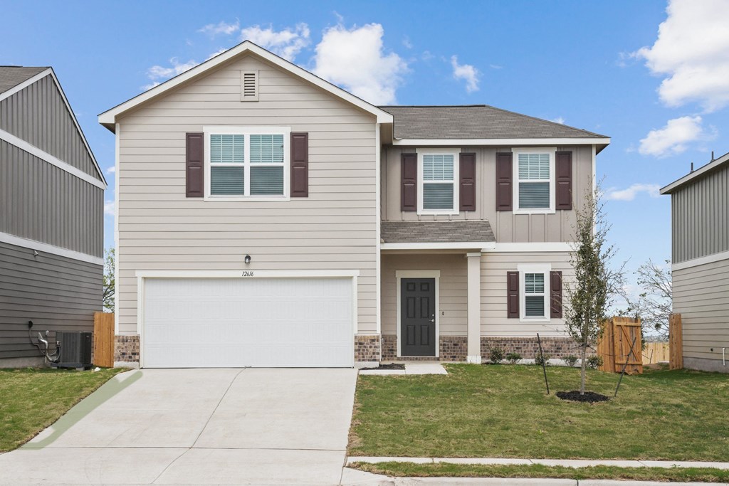 a house with a green lawn and a blue sky in the background at Beacon at Presidential Heights, Manor