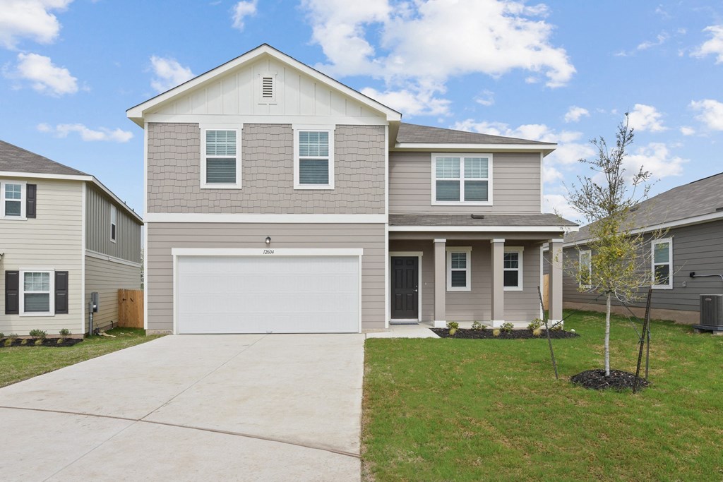 a house with a white garage door in front of a green lawn at Beacon at Presidential Heights, Manor Texas