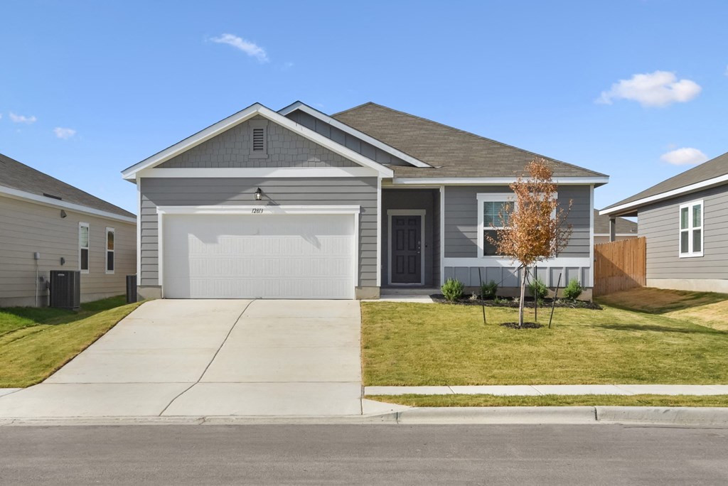 a home with a gray siding and a white garage door at Beacon at Presidential Heights, Manor, TX