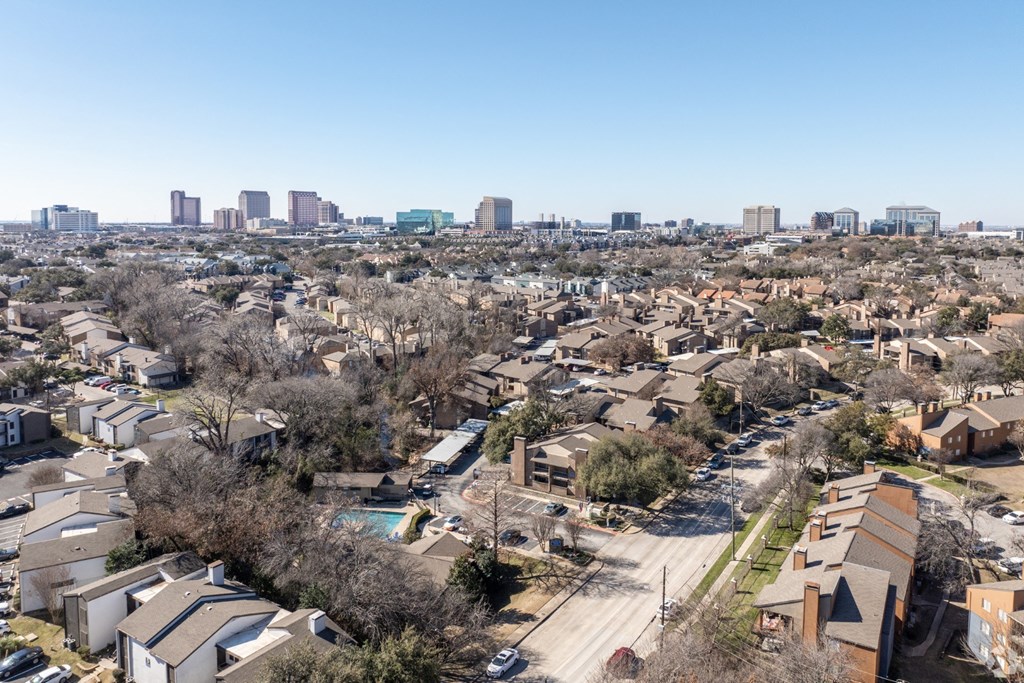 A residential area with houses and a city skyline in the background at Preston Oaks Apartments in Dallas, TX.