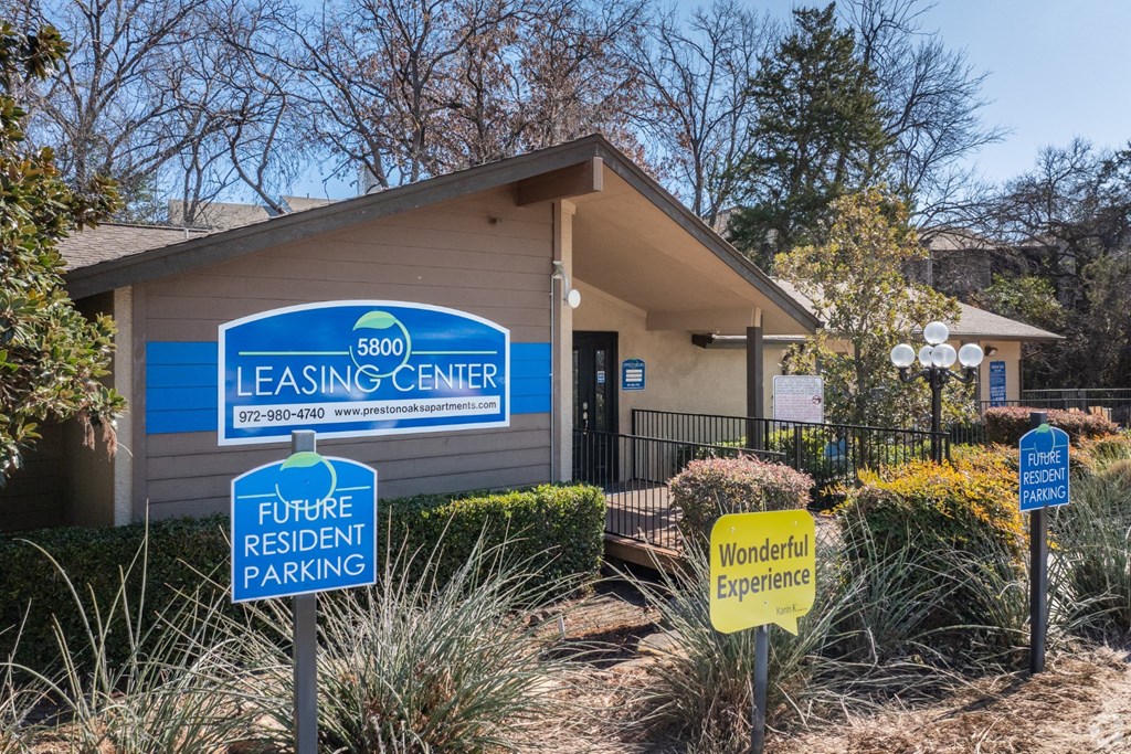 A leasing center with a sign that says "Future Resident Parking" and "Wonderful Experience" at Preston Oaks Apartments in Dallas, TX.