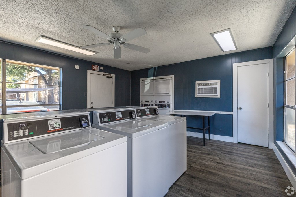 A laundry facility with washers and dryers at Preston Oaks Apartments in Dallas, TX.
