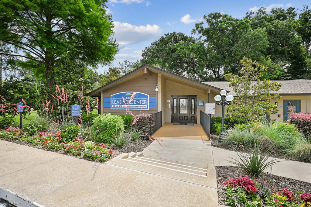 A leasing office with a sign in front of it at Preston Oaks Apartments in Dallas, TX.