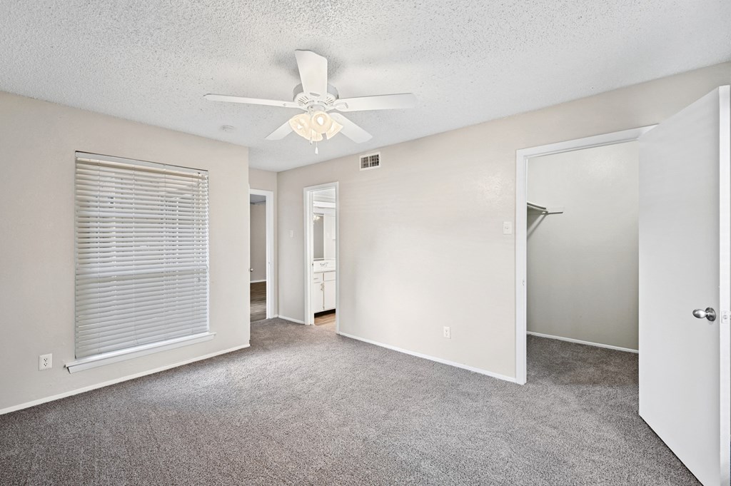 a bedroom with a ceiling fan and closet
