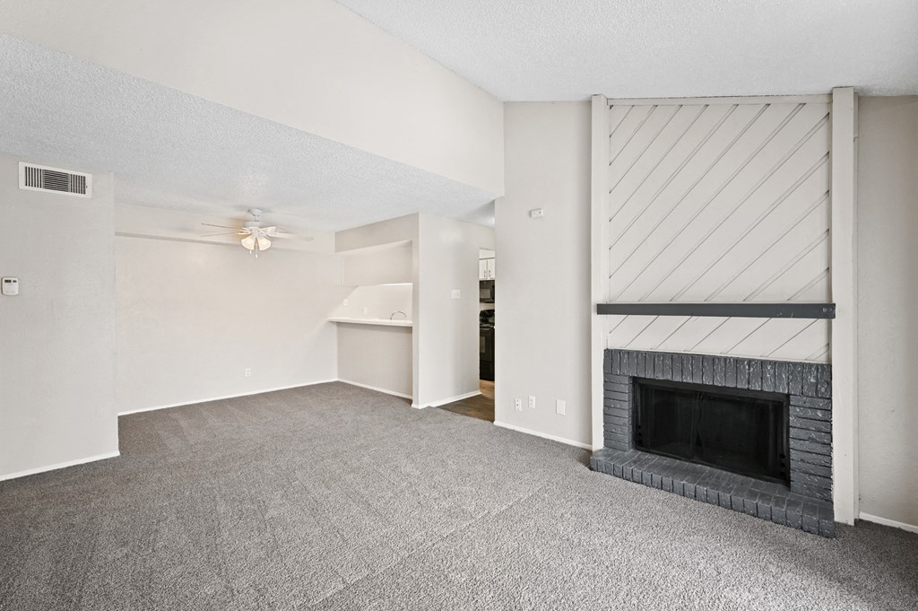 a living room with a fireplace and a ceiling fan